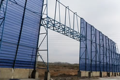 A windbreak panel wall with a door hole to facilitate vehicle access
